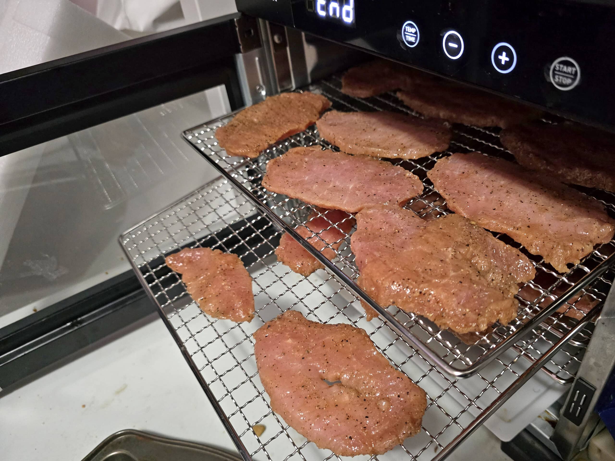 2 trays of back bacon jerky in a food dehydrator.