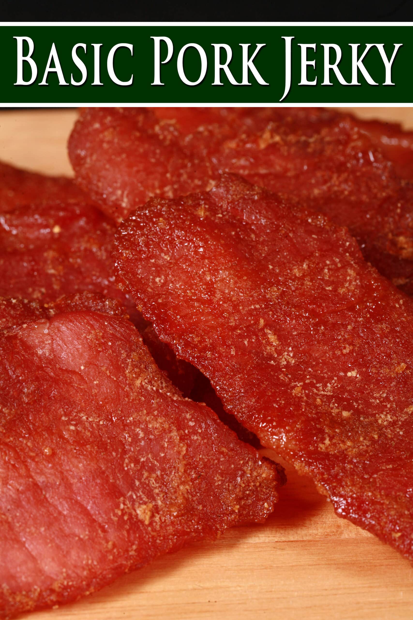 A pile of pork jerky slices on a wooden cutting board. Overlaid text says basic pork jerky.
