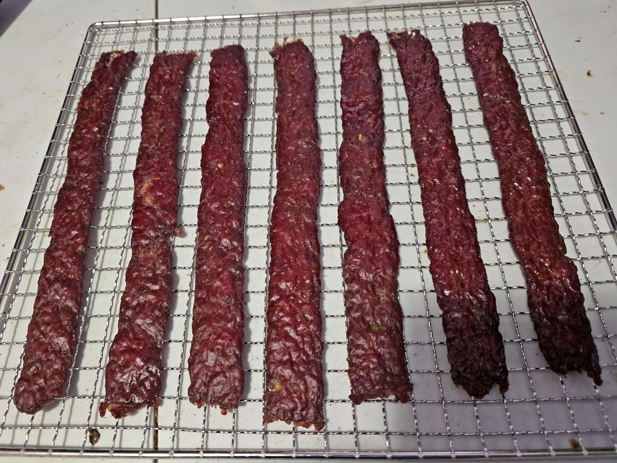 A rack of finished peppered ground venison jerky.