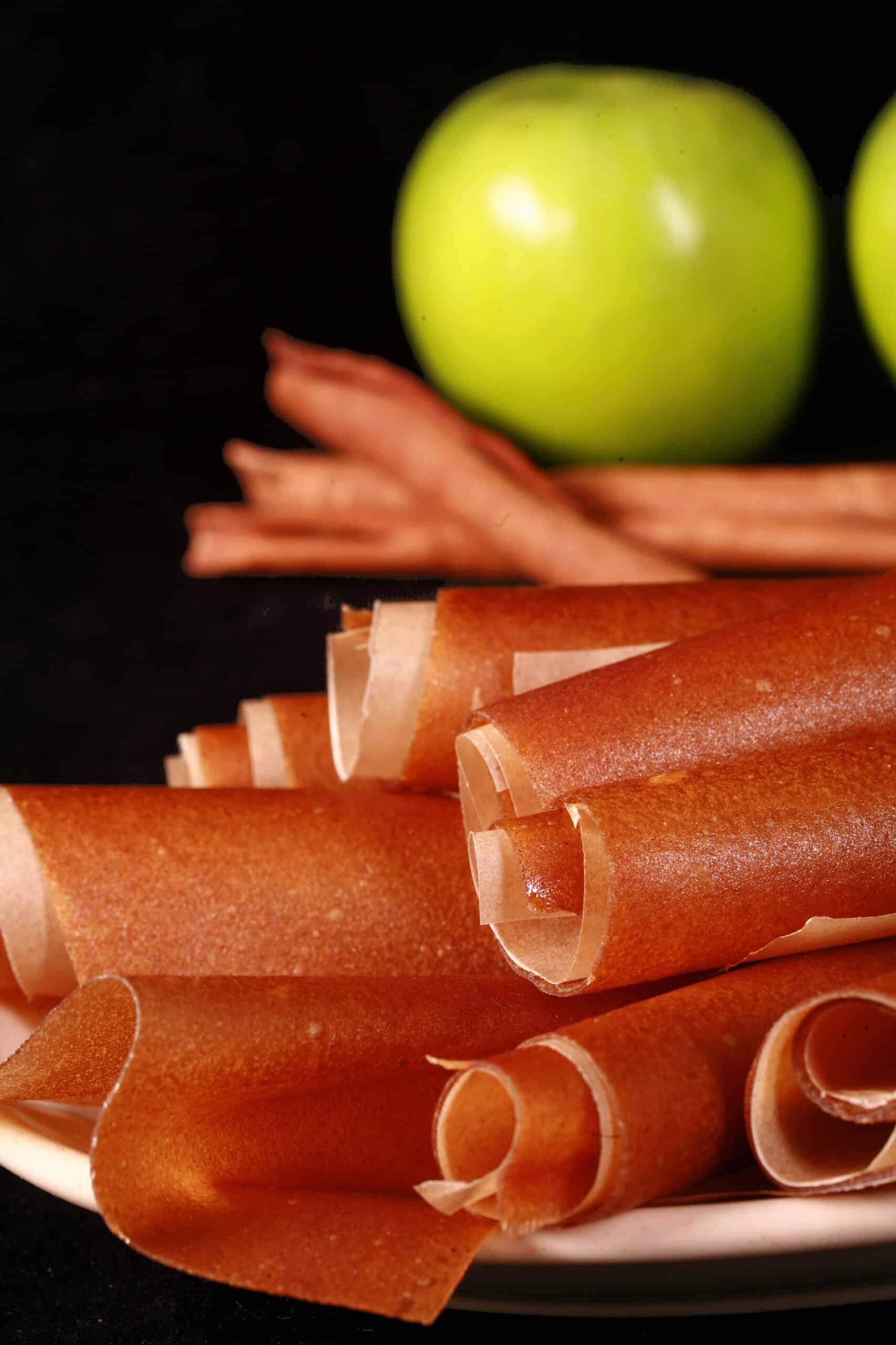 A plate of homemade apple cinnamon fruit leather rolls.