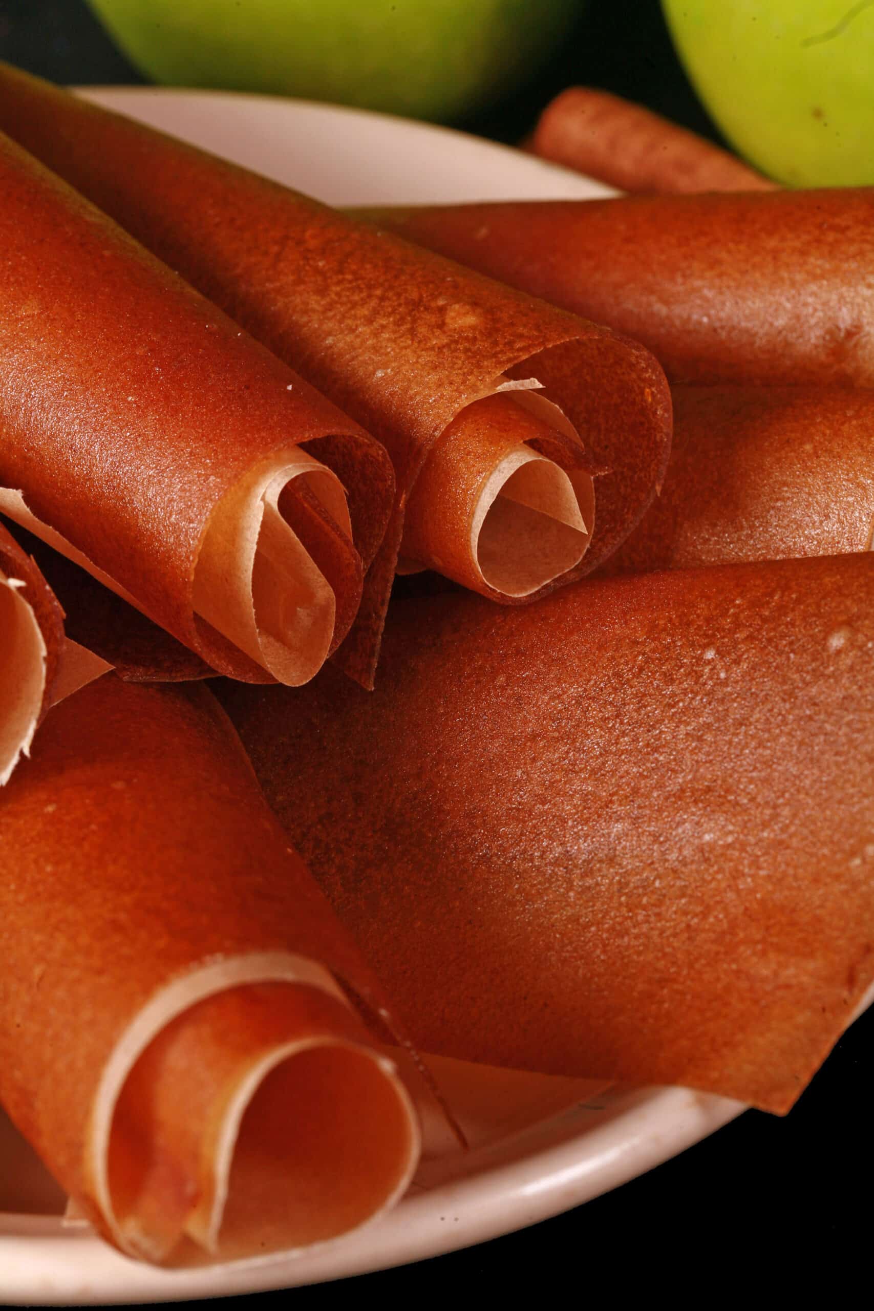 A plate of homemade cinnamon apple fruit leather rolls.