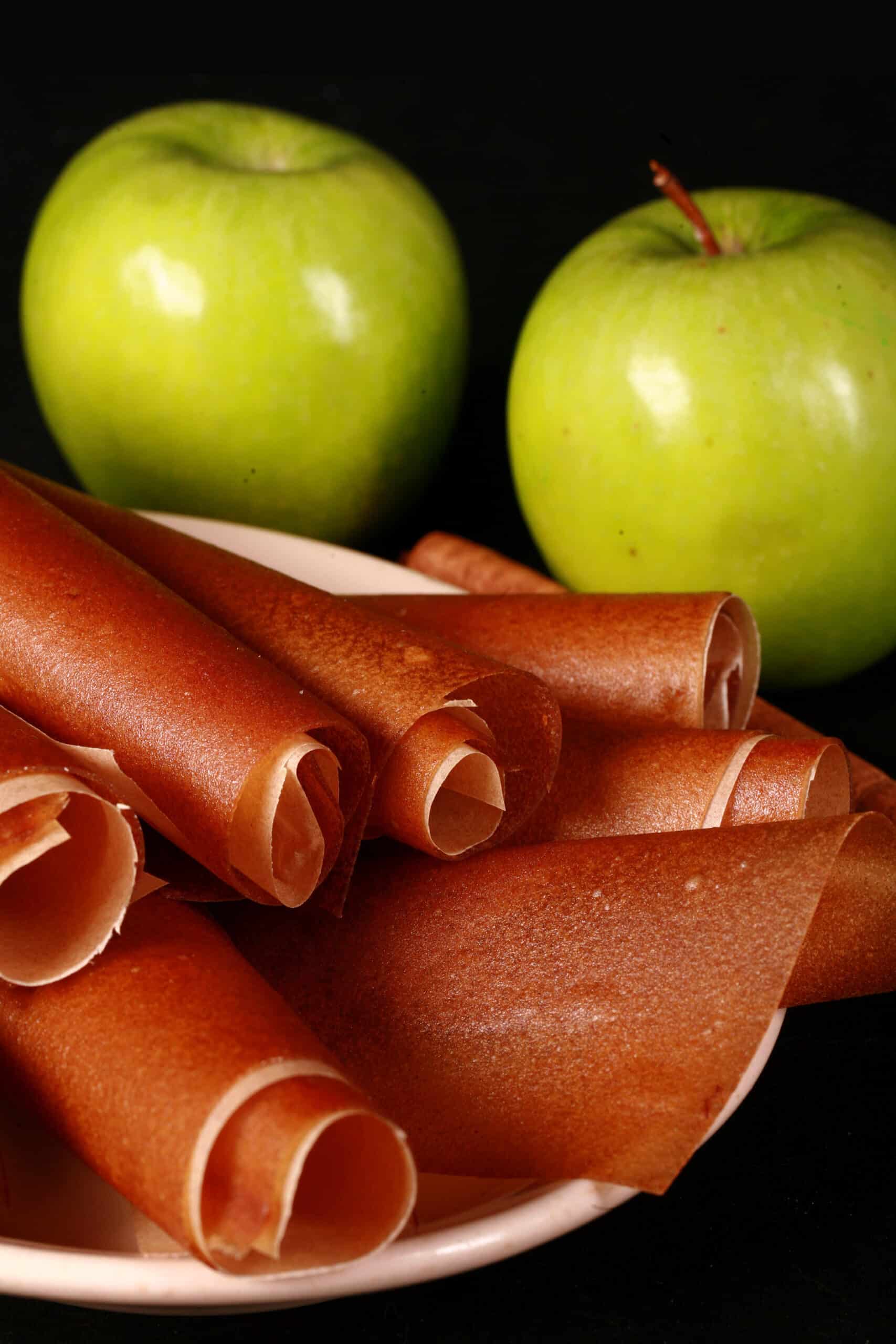 A plate of homemade cinnamon apple fruit leather rolls.