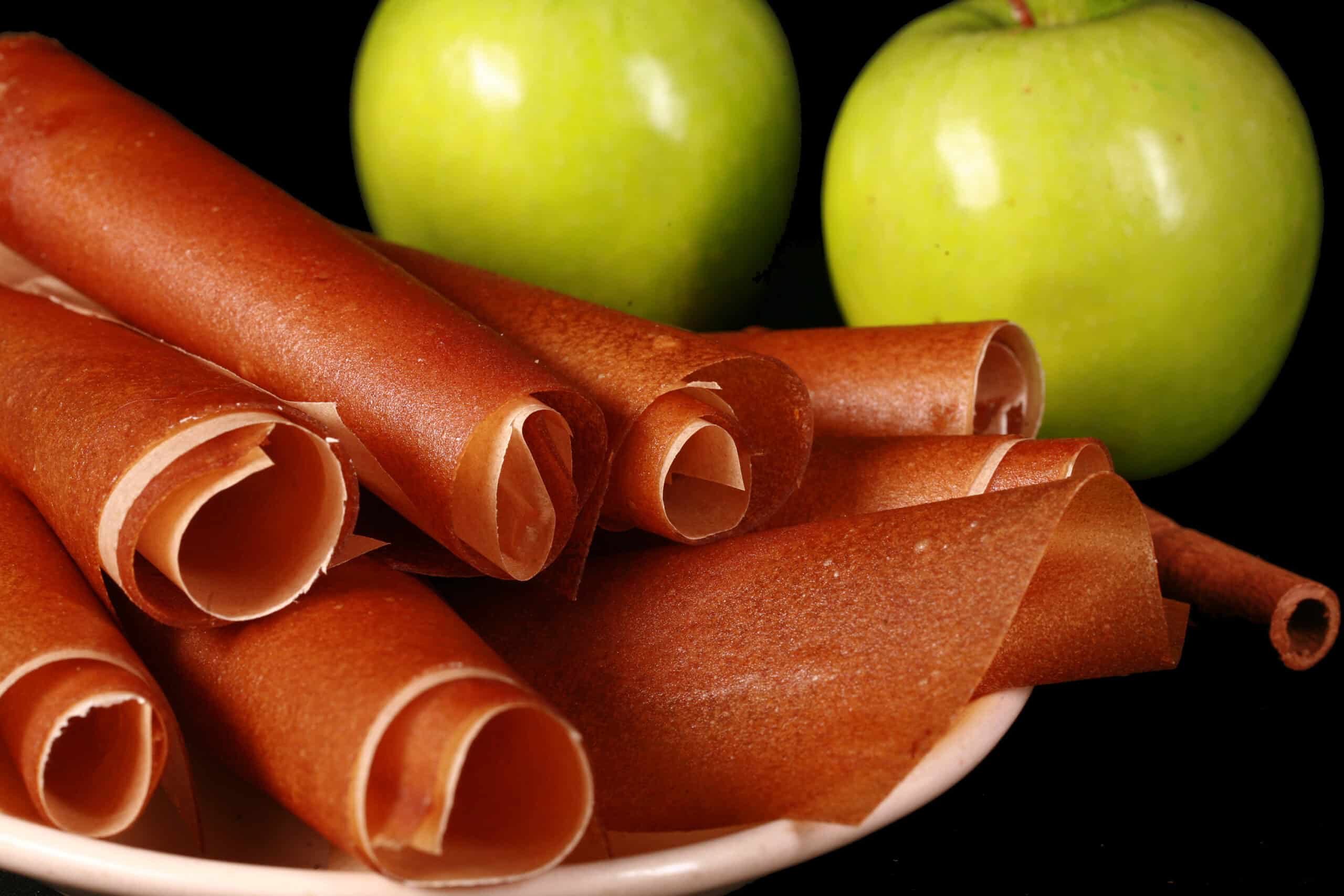A plate of homemade cinnamon apple fruit leather rolls.