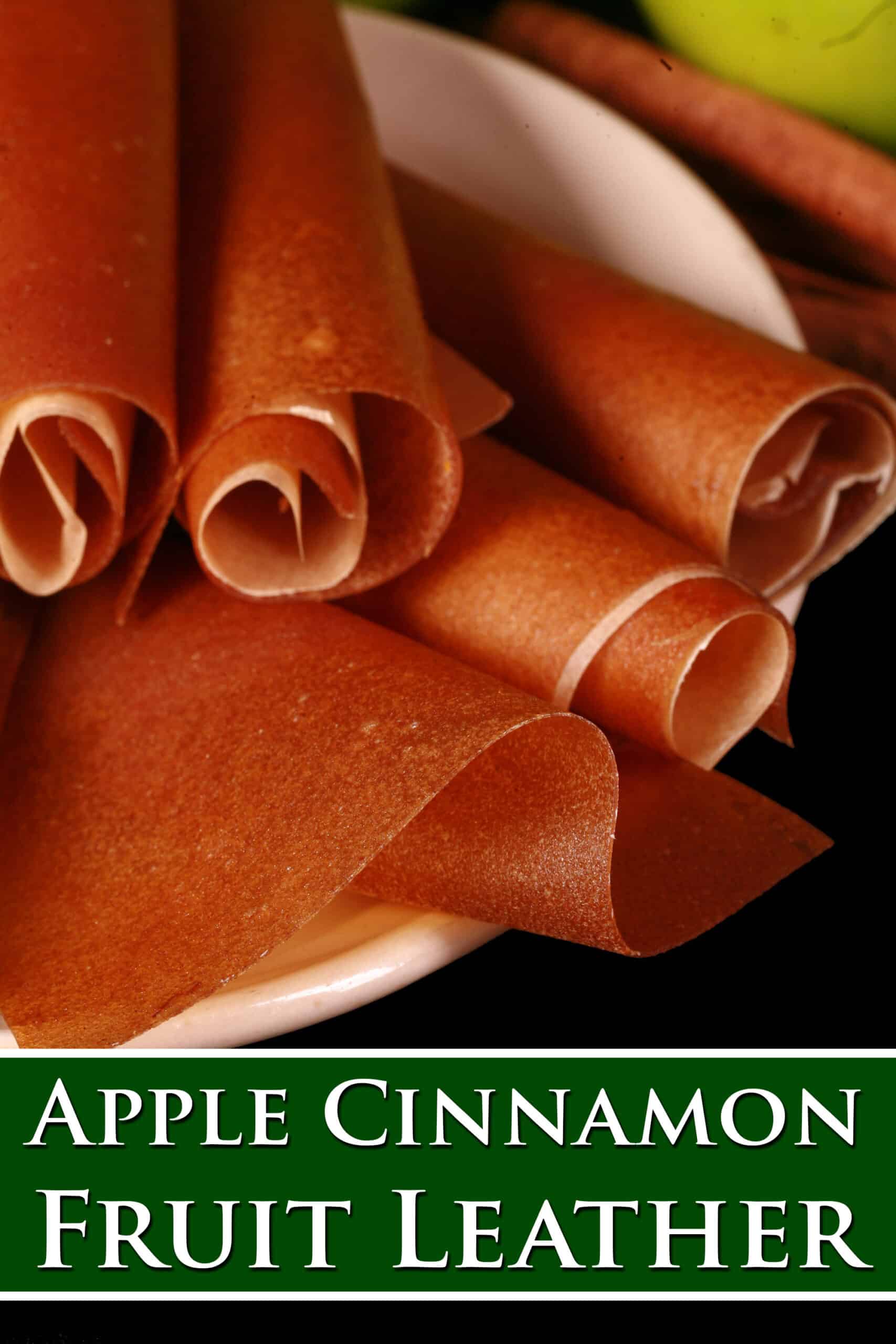 A plate of homemade cinnamon apple fruit leather rolls. Overlaid text says apple cinnamon fruit leather.