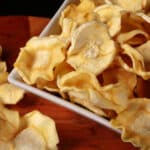 A bowl of crispy dehydrated parsnip chips.