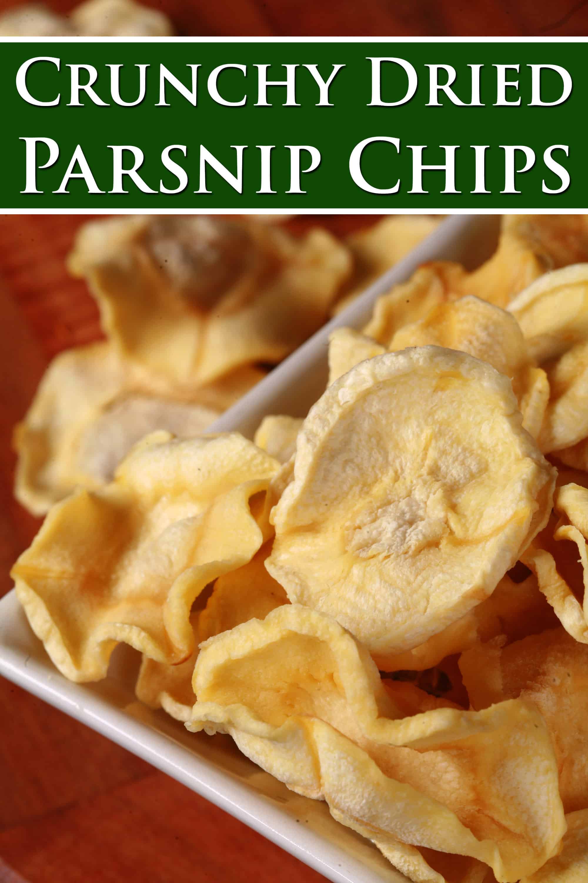 A bowl of crispy dehydrated parsnip chips. Overlaid text says crunchy dried parsnip chips.