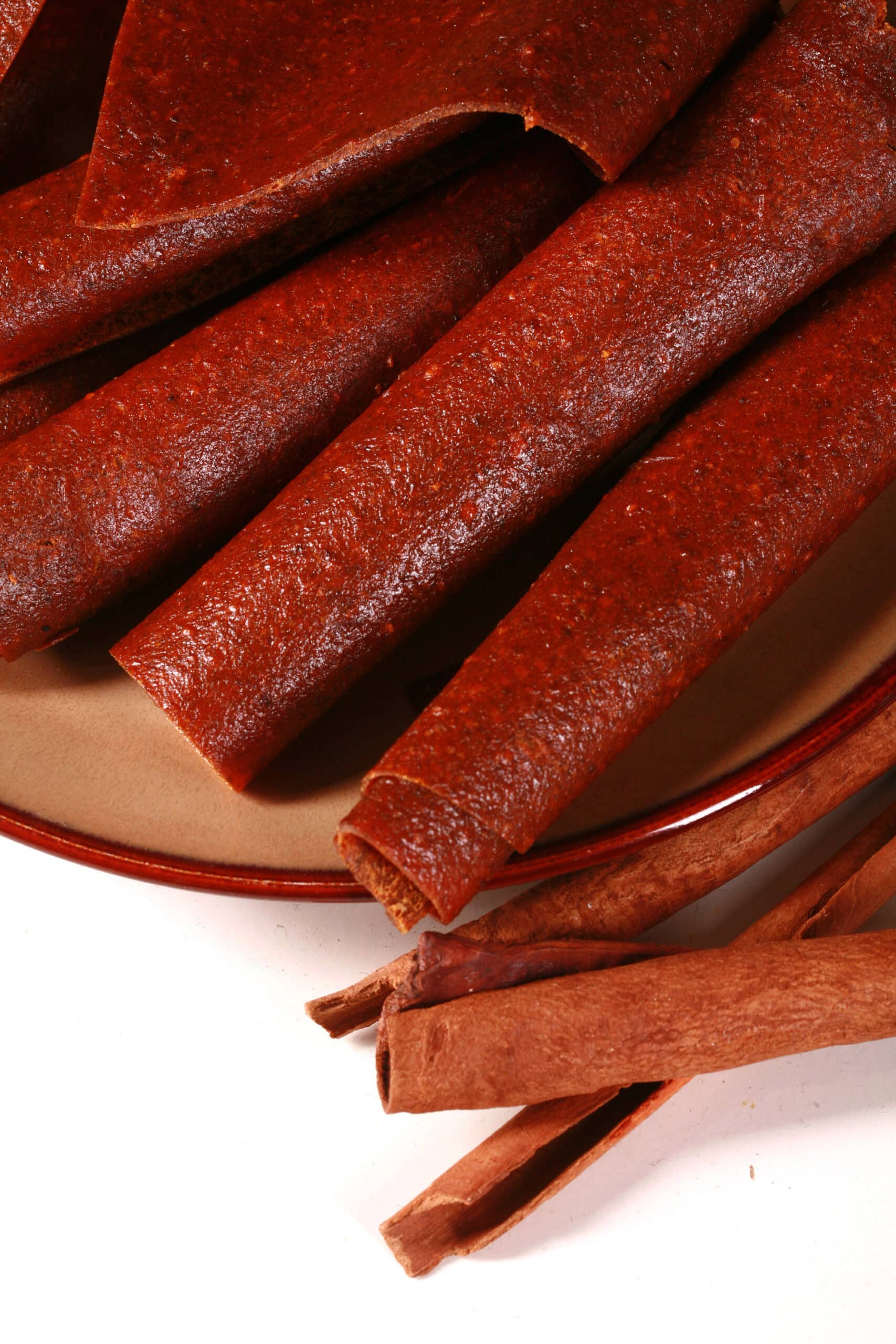 A plate with several rolls of pumpkin spice fruit leather.
