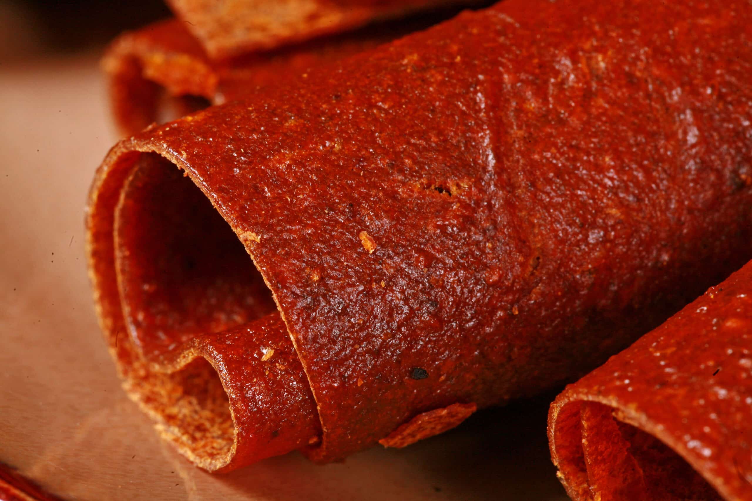 A plate with several rolls of pumpkin fruit leather.