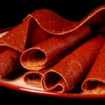 A plate with several rolls of pumpkin spice fruit leather.