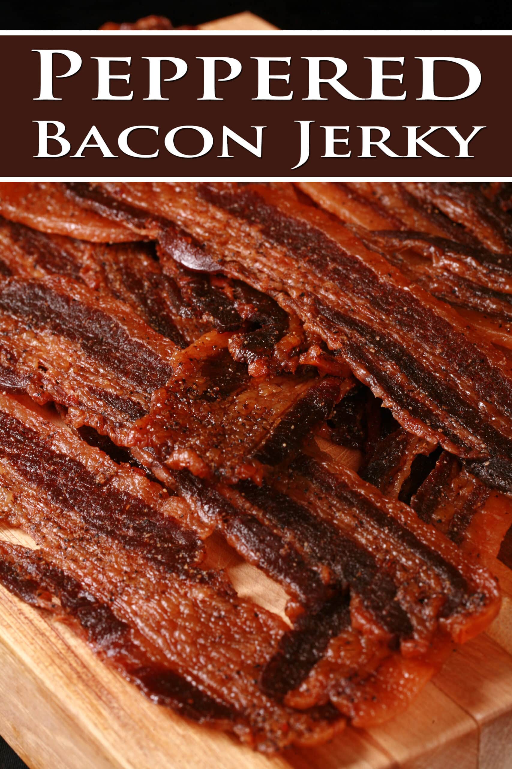 A pile of black pepper bacon jerky on a cutting board. Overlaid text says peppered bacon jerky.